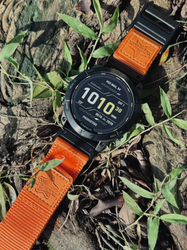 Orange nylon QuickFit watch band and Garmin watch displayed on outdoor ground