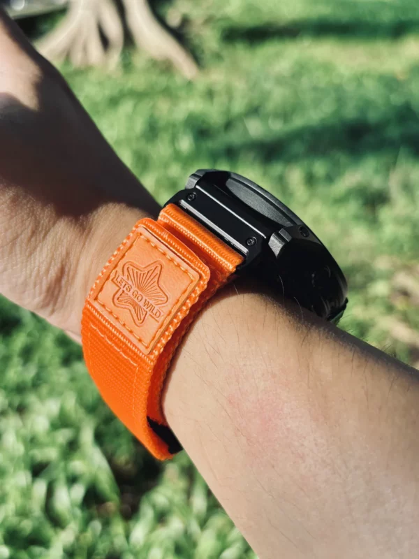 Orange nylon QuickFit watch band shown from the side on a wrist