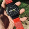 Red HEMSUT nylon QuickFit watch band installed on a Garmin watch outdoors