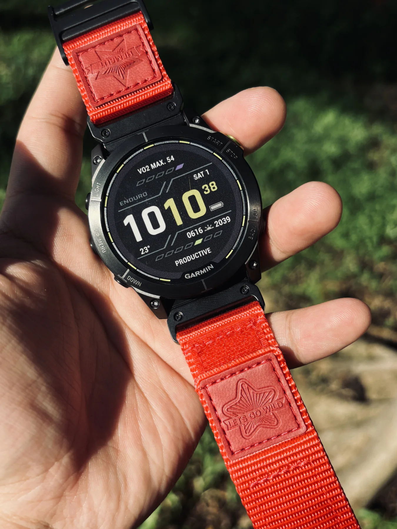 Red HEMSUT nylon QuickFit watch band installed on a Garmin watch outdoors