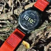 Red nylon QuickFit watch band and Garmin watch resting on a rock outdoors
