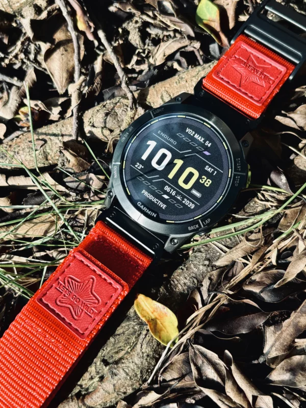 Red nylon QuickFit watch band and Garmin watch resting on a rock outdoors