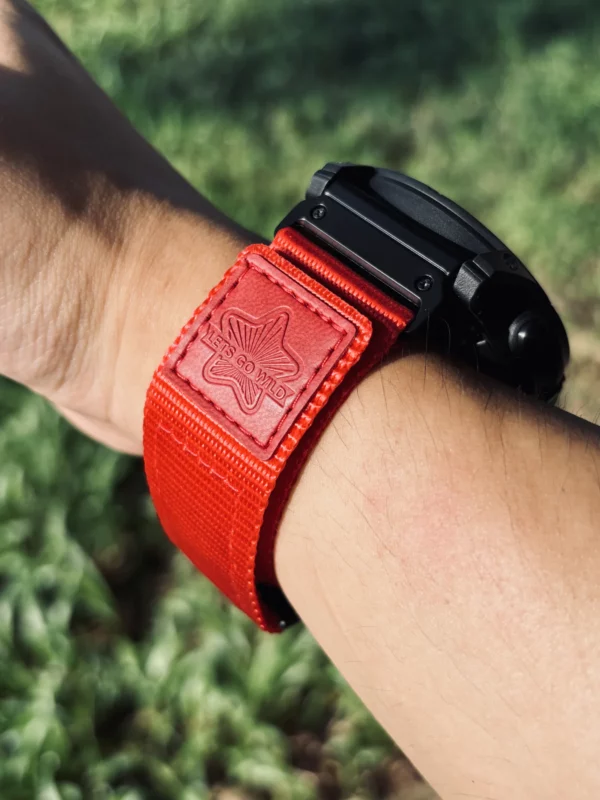 Red nylon QuickFit watch band shown from the side on a wrist